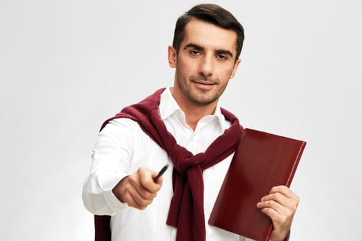 handsome man in a white shirt sweater on the shoulders notebook posing business and office concept