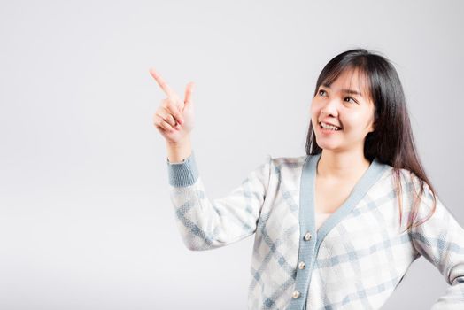Smiling happy woman pointing finger out space