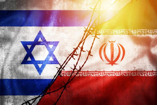 Grunge flags of Iran and Israel divided by barb wire sun haze illustration