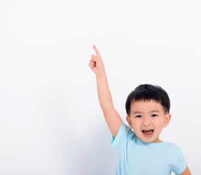 Happy little boy pointing to copy space