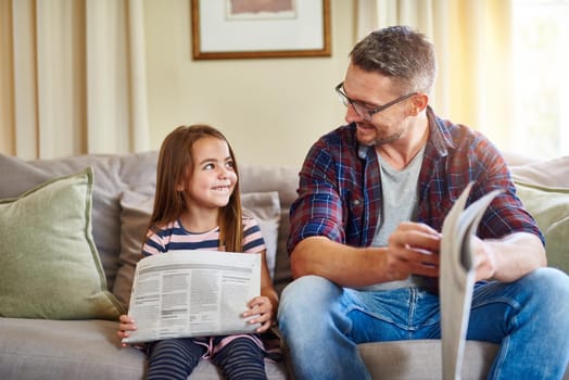 Being your parent is my favourite job. Shot of a father and daughter reading the newspaper.