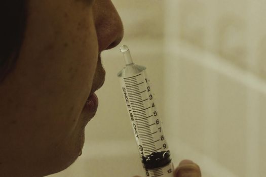 Using a syringe to rinse the nose