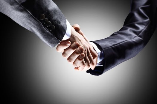 Close-up of business people shaking hands to confirm their partnership