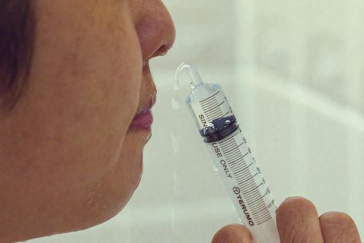Using a syringe to rinse the nose