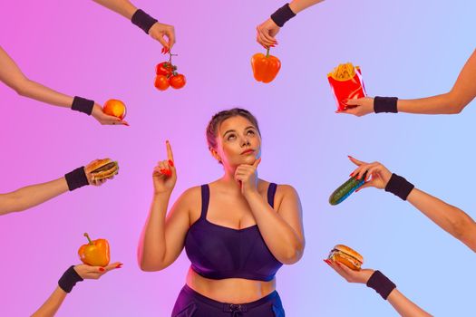 Fat girl, Plus size model girl in front of a difficult food choice. What to choose vegetables, fruits, meat, or fast food. Idea for a social media post about diet and weight loss