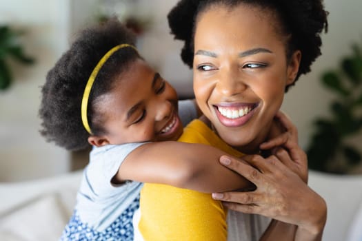 Close up of african american girl hugging her mother from behind at home
