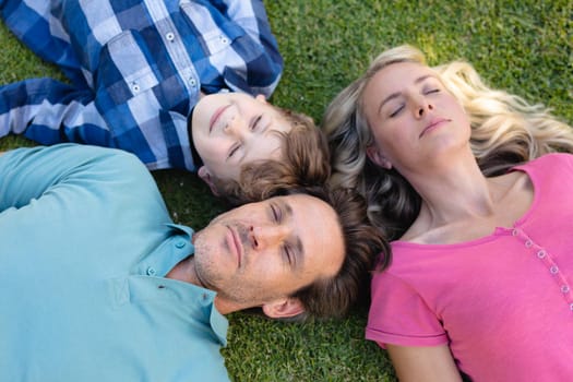Overhead view of caucasian family lying together in the garden