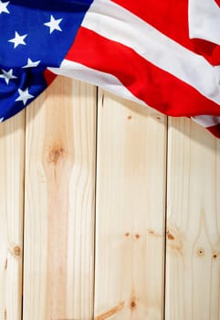 Overhead view of red and white stripes along with stars on america flag over wooden table