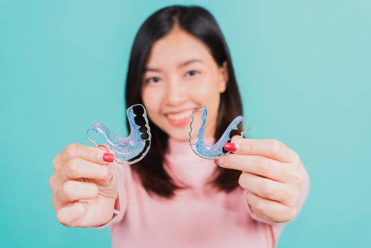 woman smiling hold silicone orthodontic retainers for teeth