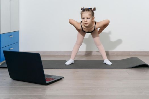 online training of a Caucasian girl gymnast 5 years old