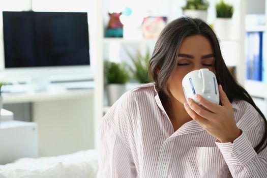 Lovely sleepy woman drink coffee to wake up in morning, caffeine for energetic day start