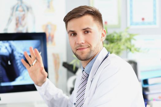 High specialist point on monitor with scan, intelligent man doctor wear white medical uniform