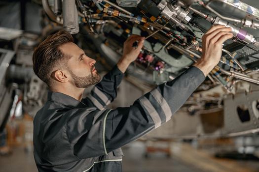 Male maintenance technician repairing airplane in hangar