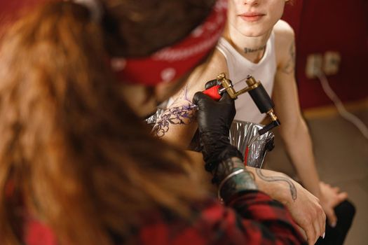 Close up of hands of master holding tattoo machine