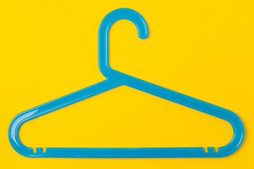 Hanger on colored paper background. Minimalistic fashion concept.