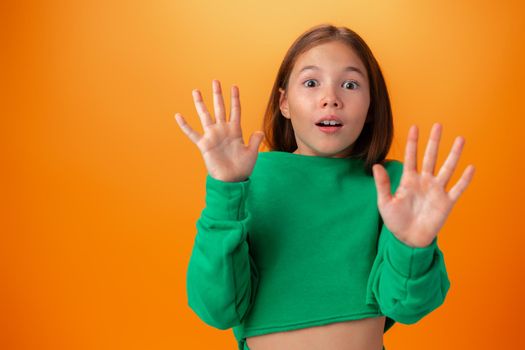 Photo of worried nervous teen girl afraid of something against orange background