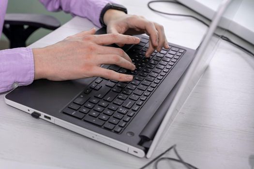 Man working at home office hand on keyboard close-up