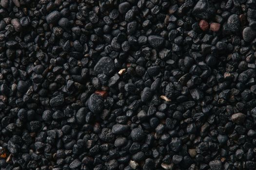 Texture of black volcanic sand for background. Black Sand beach macro photography. Close-up view of volcanic sand surface. Icelandic Black Sand macro photography. Black pebble background