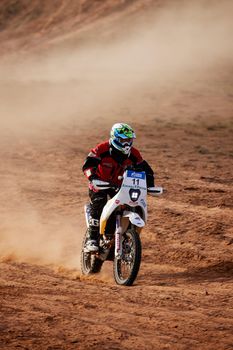 Rider on a off-road motorbike on the desert rally. Rally raid THE GOLD OF KAGAN-2021. 24.04.2021 Astrakhan, Russia.