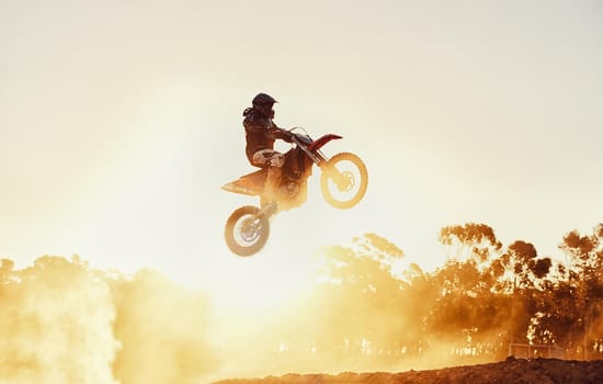 Hes way out in front. A shot of a motocross rider in midair during a race.