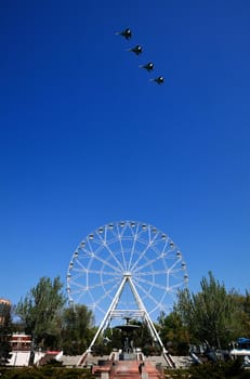 Rehearsal of the air parade in honor of the 75th anniversary of the end of World war II. Flying aircraft on the background of the Ferris wheel on theater square. 30.04.2020, Rostov-on-Don, Russia.
