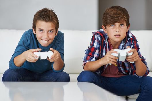 Im gonna beat you. Shot of two young boys concentrating while playing video games.
