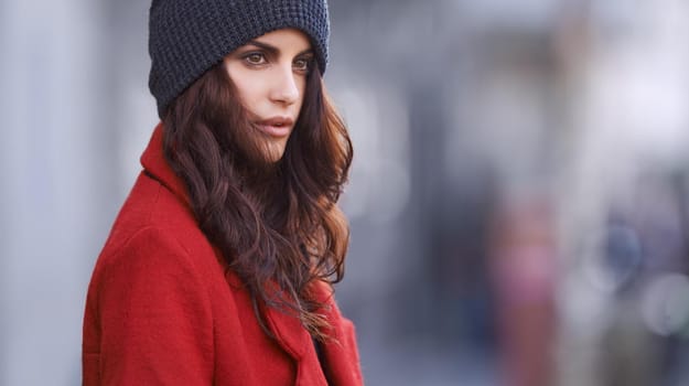 When in doubt wear red. Shot of a beautiful young woman in winter clothing standing in an urban setting.