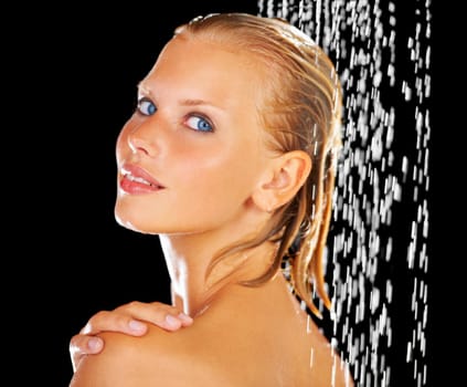 Kissed by the warm droplets. Portrait of a beautiful young woman having a refreshing shower.