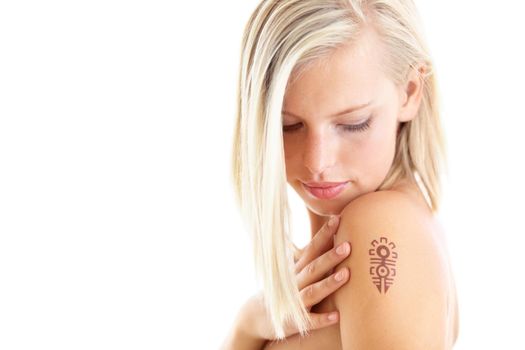 Bold beauty. Studio shot of a beautiful young woman with a tattoo on her shoulder against a white background.