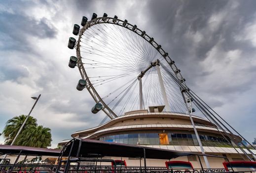 The huge ferris wheel in Singapore, a local landmark, a view from below in cloudy weather