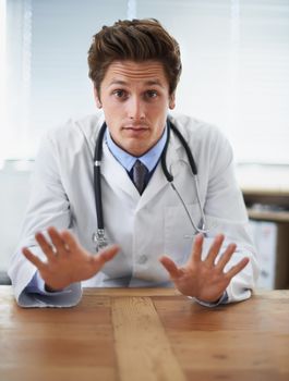 No need to worry at this point.... Shot of a young doctor gesturing not to worry to the camera.