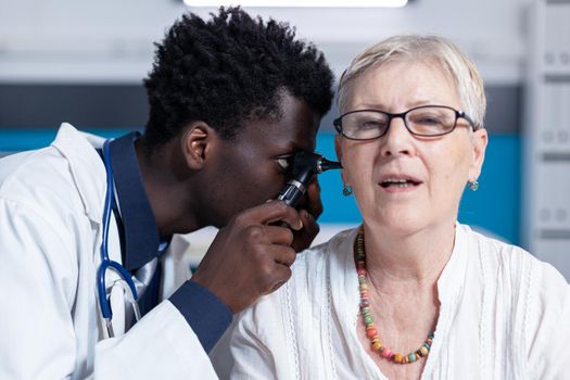 Healthcare facility otologist checking internal ear infection or illness using otoscope. Clinic otology specialist consulting sick woman ear infection to prevent otitis and other health complications.
