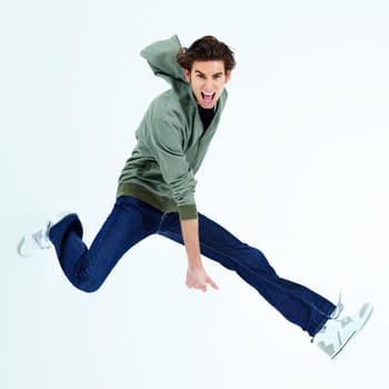 Yeah - Enjoying freedom. Portrait of a young man jumping out and shouting loudly.