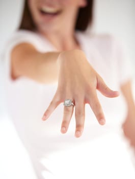 Symbols of life long love. Cropped shot of a womans hand displaying an engagement ring.