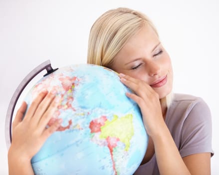 Oh world, I love you. A pretty young woman hugging a globe of the earth lovingly.