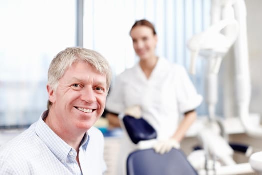 Smiling doctor with assistant. Portrait of handsome dentist smiling with his assistant in office.