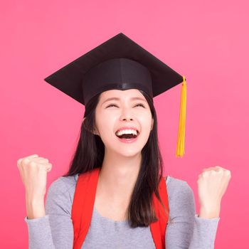Happy Asian  college student in Graduation cap  with success gesture