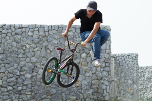 Go big or go home. A BMX rider doing tricks out in the city.