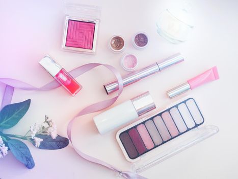 set of beauty cosmetics for female face and eye makeup on pink background.