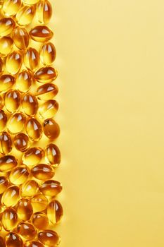 Capsules in a shell with Omega-3 fish oil on a yellow background and a place for text