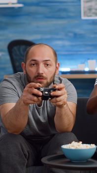 Modern interracial couple playing video game on TV