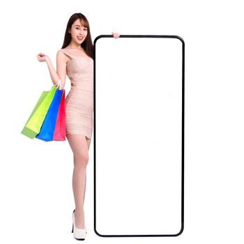 Happy young woman standing and Leaning big Smartphone With Blank White Screen. shopping online with mobile phone concepts