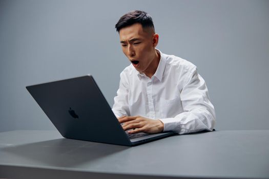 Asian man in a white shirt work laptop fatigue executive