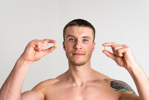 Fish oil is eaten by a man in the hands of vials and a glass bottle pill health healthy, nutrition treatment drug healthcare lifestyle, medication cod. isolated fat, health female giving dieting