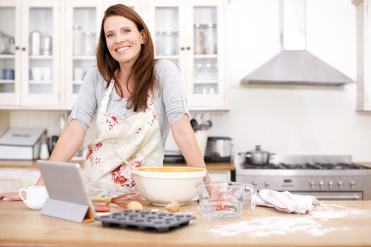 She feels relaxed when baking. Portrait of an attractive woman baking in the kitchen.