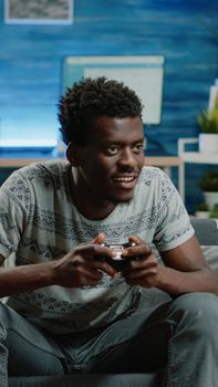 Happy man playing video games with controller on console
