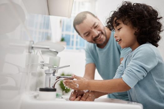 Now youll feel extra fresh. Shot of a father helping his son wash his hands and face at a tap in a bathroom at home.