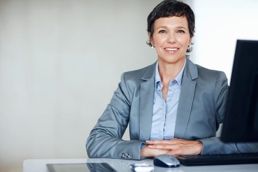 Confident business woman at office. Portrait of confident female executive smiling at office desk.