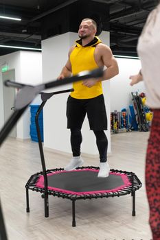 Women's and men's group on a sports trampoline, fitness training, healthy life - a concept trampoline group batut girl men, from fit athletic for gym from teamwork shaping, sportive happiness. Studio happy indoor, aerobic