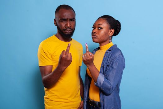 Furious couple showing middle finger in front of camera